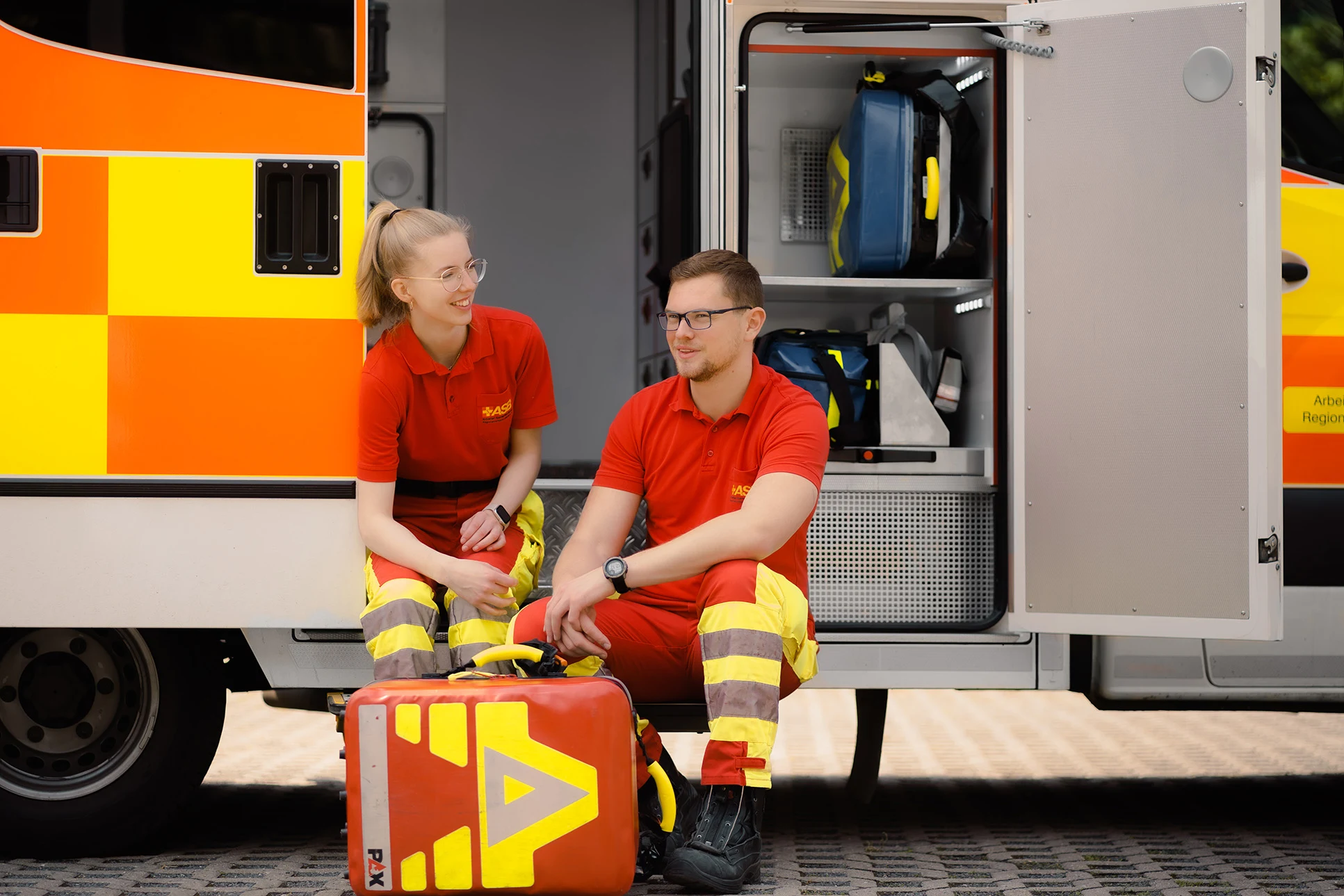 Zwei Rettungskräfte des ASB Leipzig am Heck eines Rettungswagens