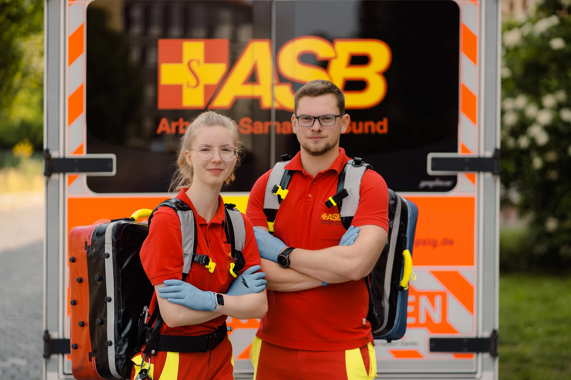 Zwei Rettungskräfte des ASB Leipzig vor einem Rettungswagen