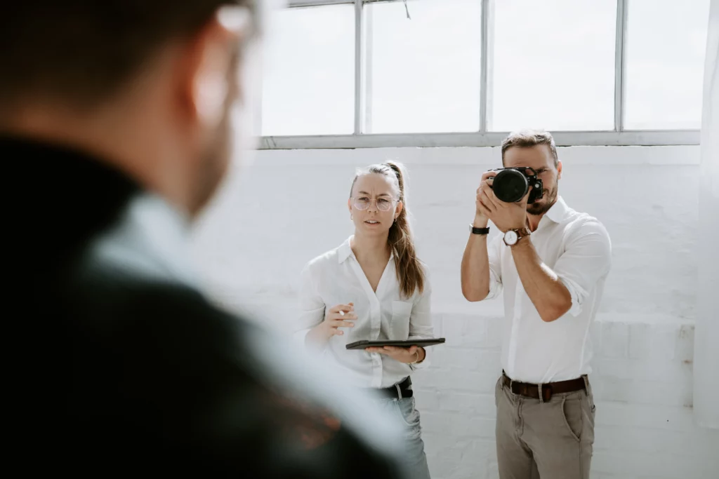 Fotograf bei einem Business-Shooting mit einer Frau im Büro