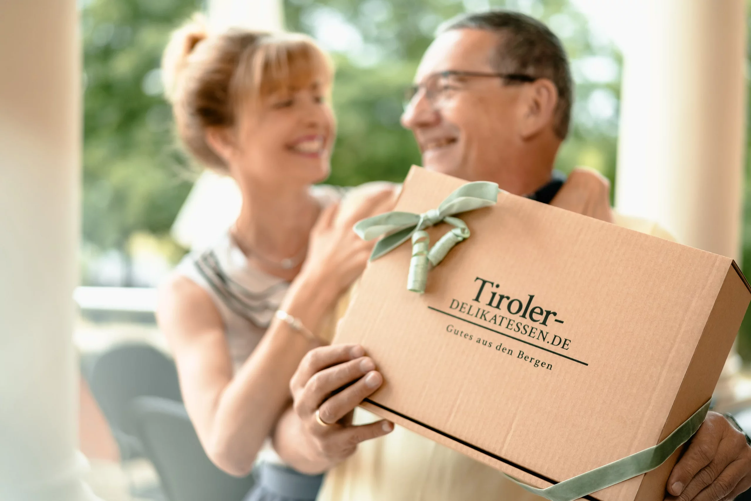 Paar freut sich über eine Geschenkbox von Tiroler Delikatessen