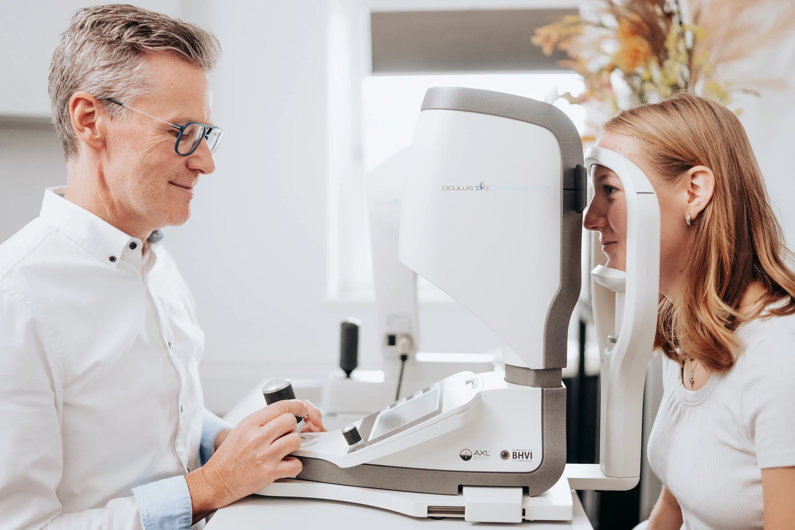 Augenoptiker führt eine Messung bei einer Kundin durch