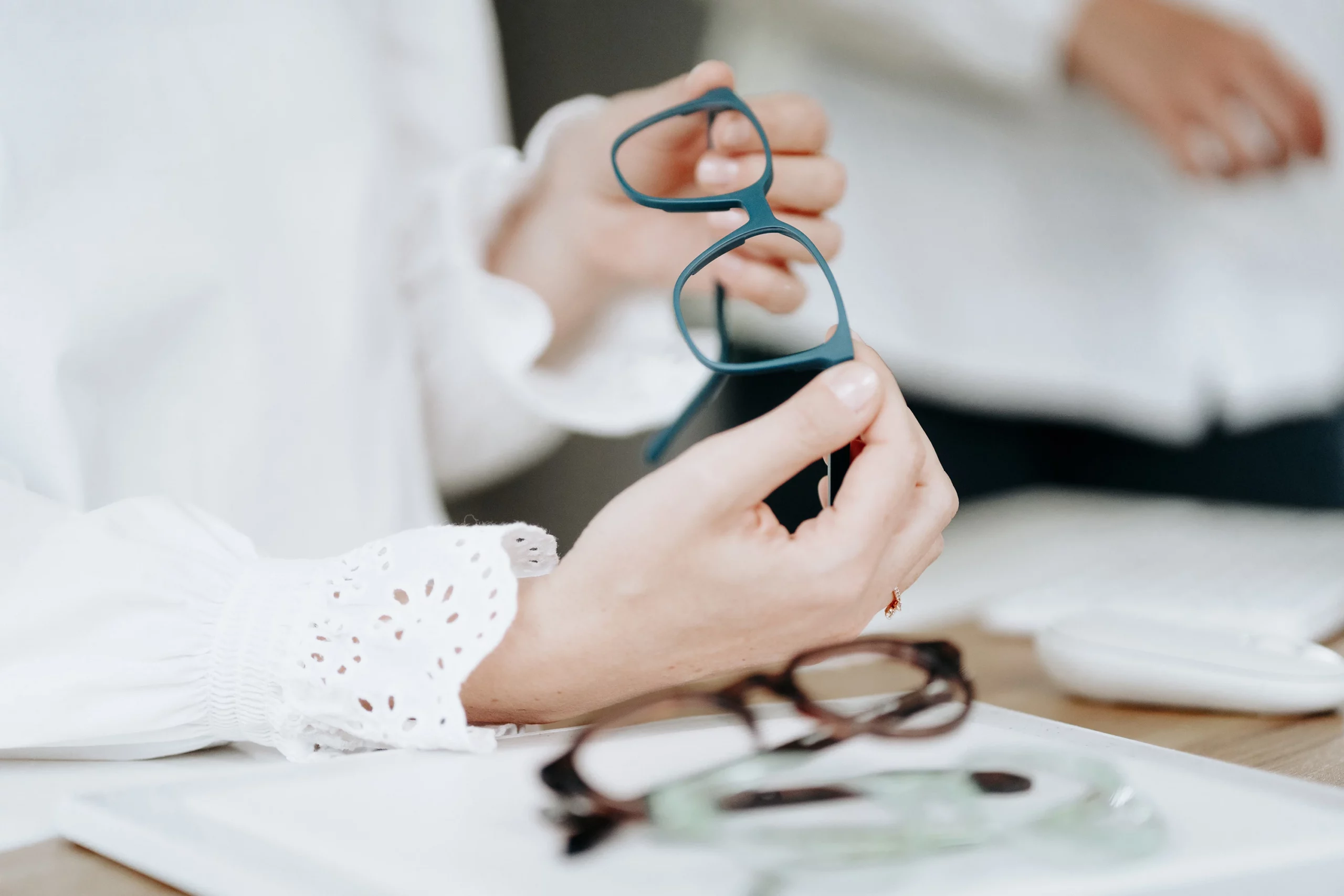 Hände halten eine Brille, Detailaufnahme beim Augenoptiker