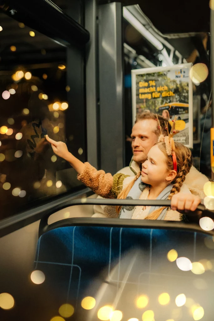 Vater und Tochter in einer Straßenbahn, Weihnachtskampagne der Leipziger Gruppe