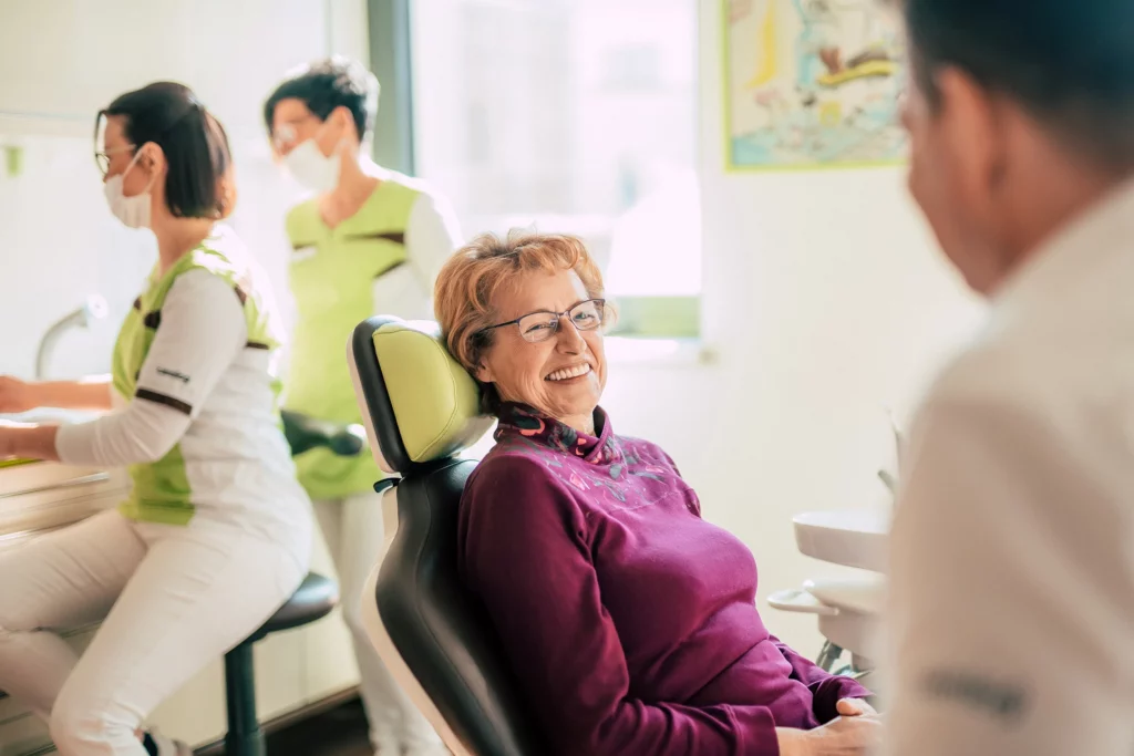 Lächelnde Patientin auf dem Behandlungsstuhl bei Dentale